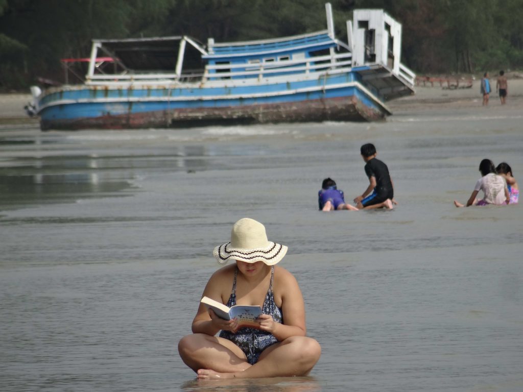 femme qui lit dans l'eau sur plage devant ananas bungalow otres beach 2 sihanoukville