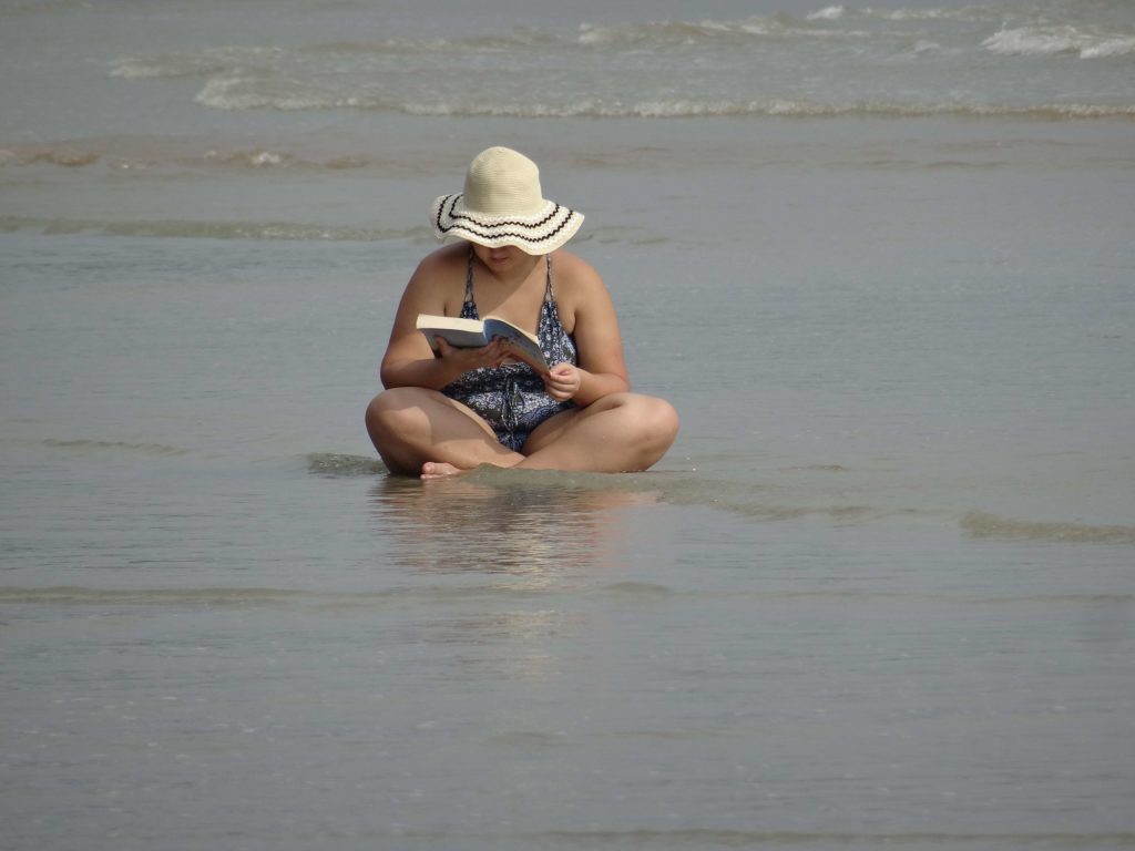 femme qui lit dans l'eau sur plage devant ananas bungalow otres beach 2 sihanoukville