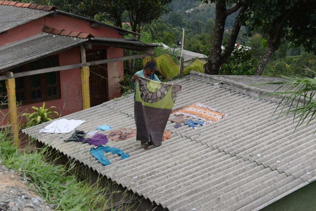 femme qui met le linge à sécher sur le toit de sa maison entre le Monastère de Adisham et notre guest-house à haputale