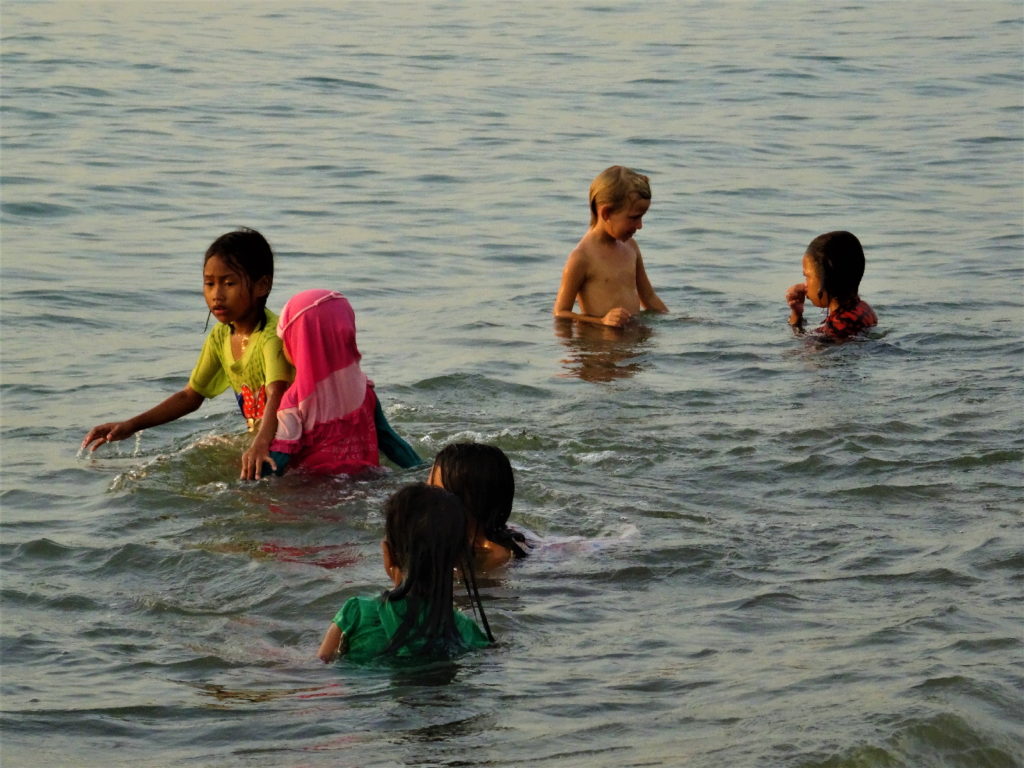 chatounette et enfants qui se baignent habillés à la plage pantai merdeka près de makassar