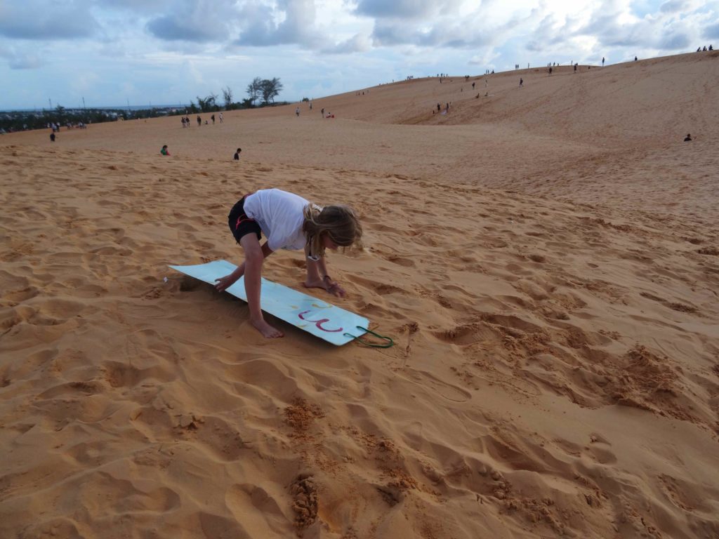 chatounette fait de la luge dans les dunes de sables rouges à Mui Ne