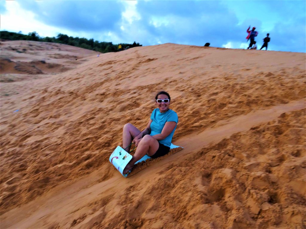 chatoune fait de la luge dans les dunes de sables rouges à Mui Ne