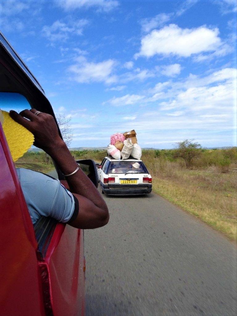 trajet en taxi-brousse entre sambave et ambilobe, depuis le véhicule, on double une voiture au toit très chargé