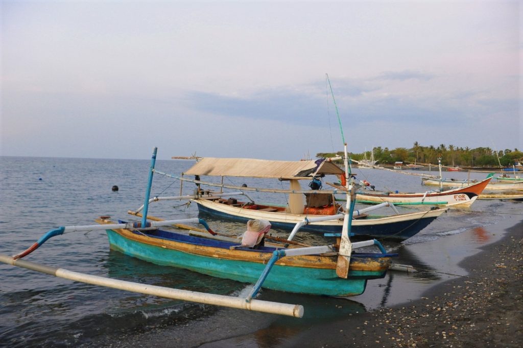 plage au coucher du soleil de pemuteran, bateaux sur l'eau
