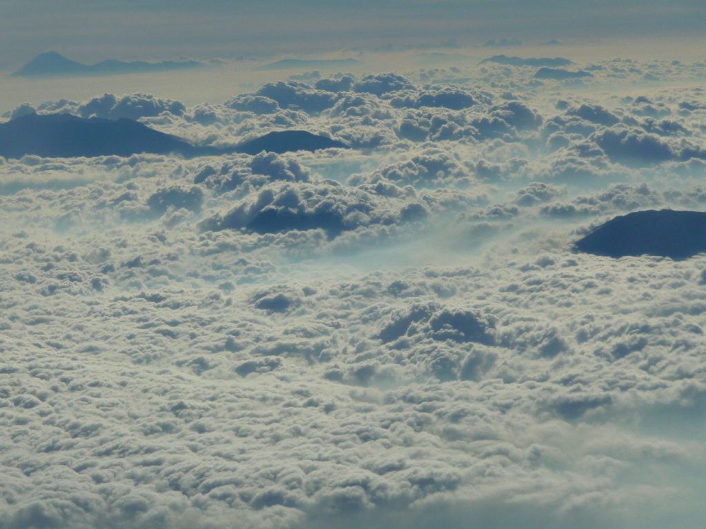 mer de nuages au-dessus des volcans indonésiens, vue depuis le hublot de l'avion