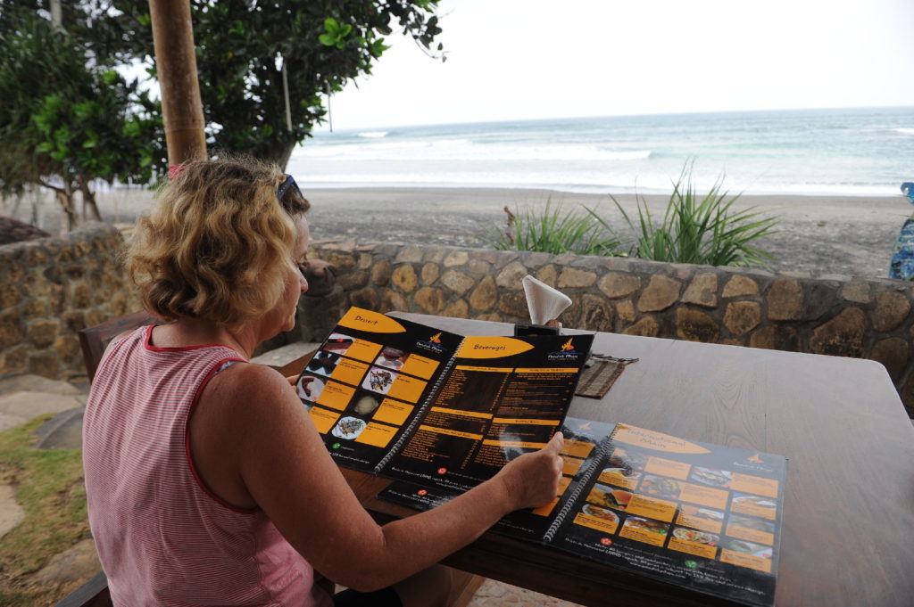 mamisa regarde le menu de la resort face au spot de surf de balian beach