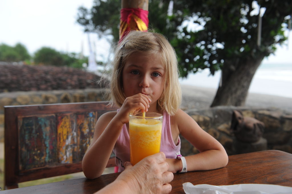 chatounette en train de boire une orange pressée face au  spot de surf de balian beach