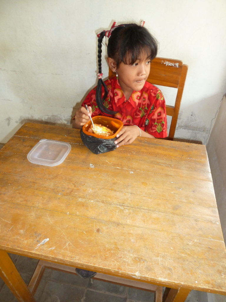 repas pris par une élève dans sa classe dans une école indonésienne près de balian beach