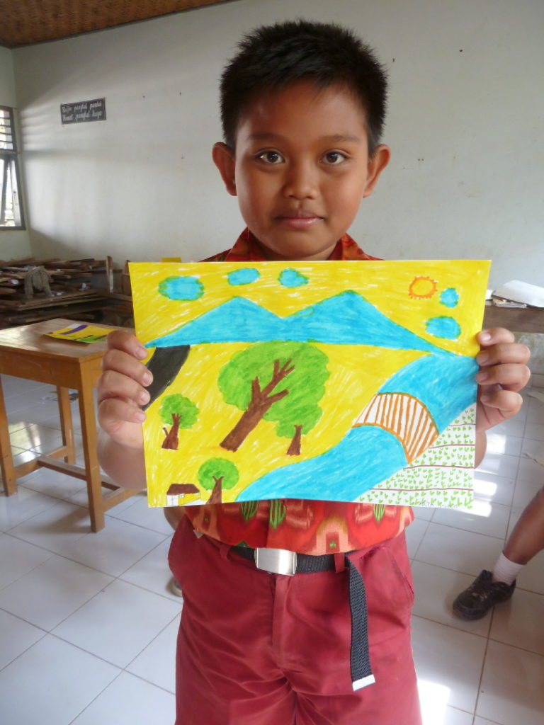 élève et son dessin dans une classe d'une école primaire indonésienne près de balian beach