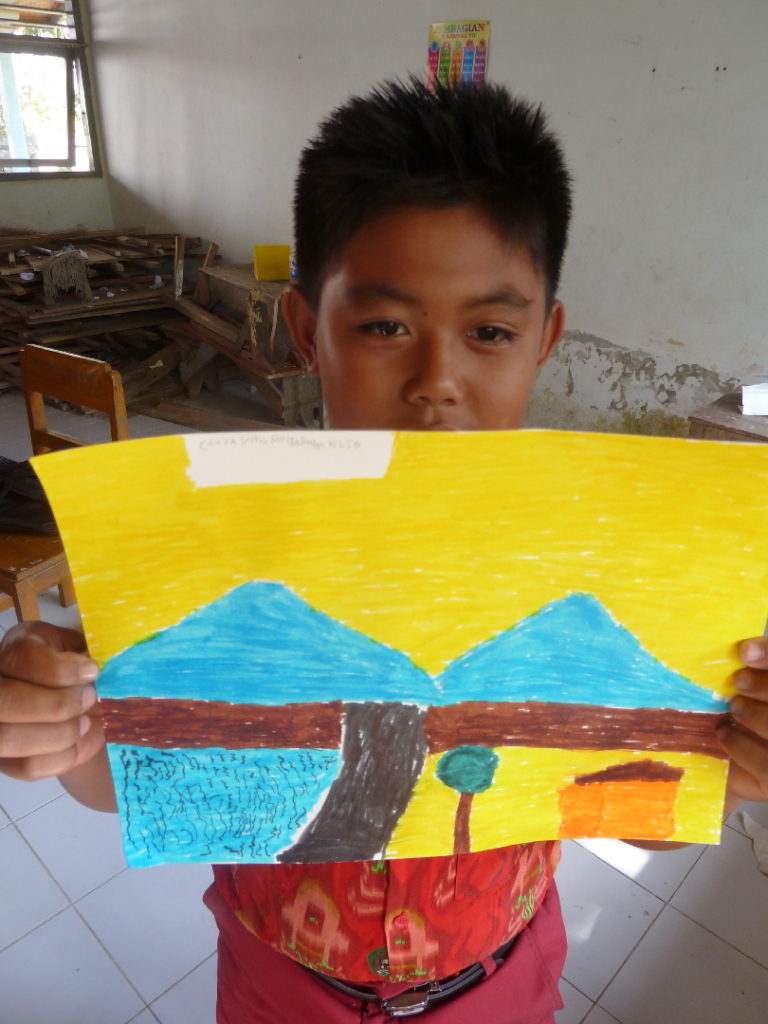 élève et son dessin dans une classe d'une école primaire indonésienne près de balian beach