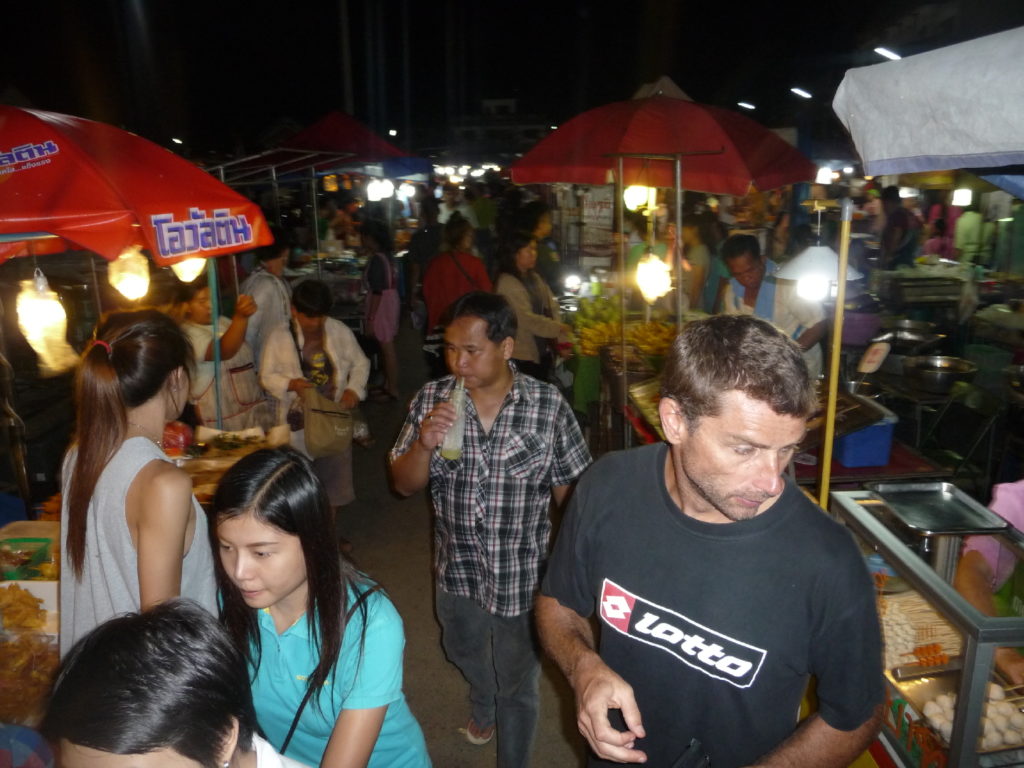 chaton ne sait plus donner de la tête parmi tous les stands de nourriture du marché nocturne de phayao