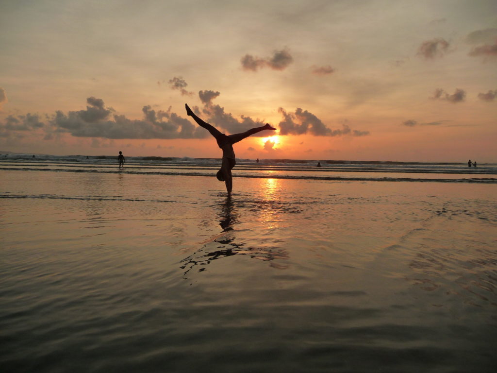 chatoune qui fait des équilibres dans le sable au moment du coucher de soleil sur la plage de Kuta Bali