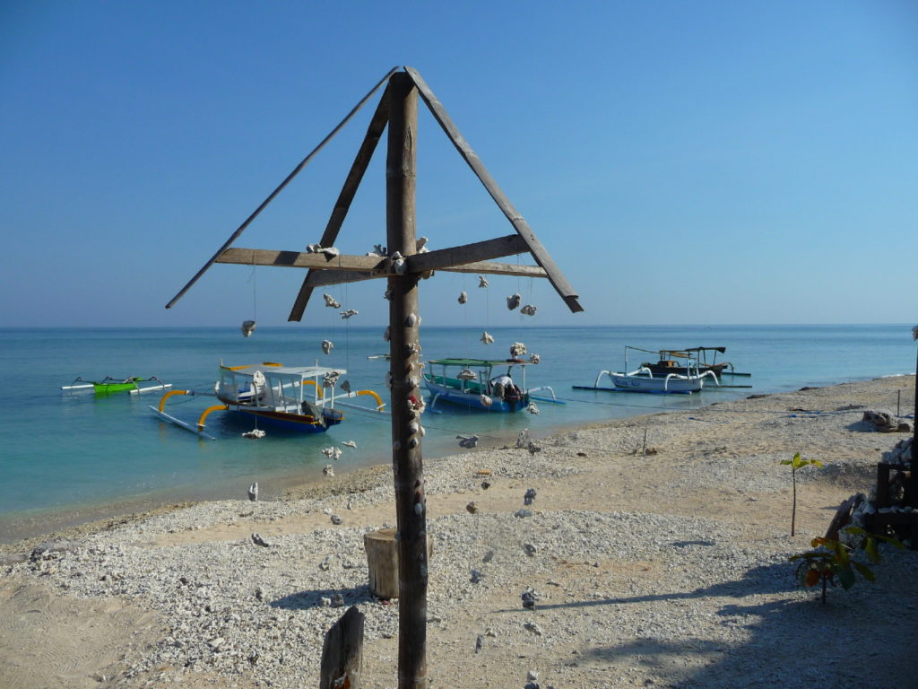 portique décoratif avec des guirlandes de coquillage sur une plage de gili air