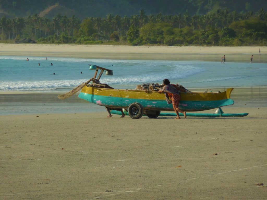 mise à l'eau d'un bateau sur la plage paradisiaque de selong belanak, près de kuta lombok