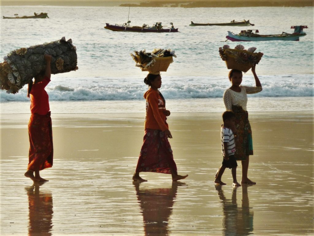 Selong Belanak, plage de rêve de Lombok, au coucher du soleil, femmes de pêcheurs défilant avec leurs paniers sur la tête
