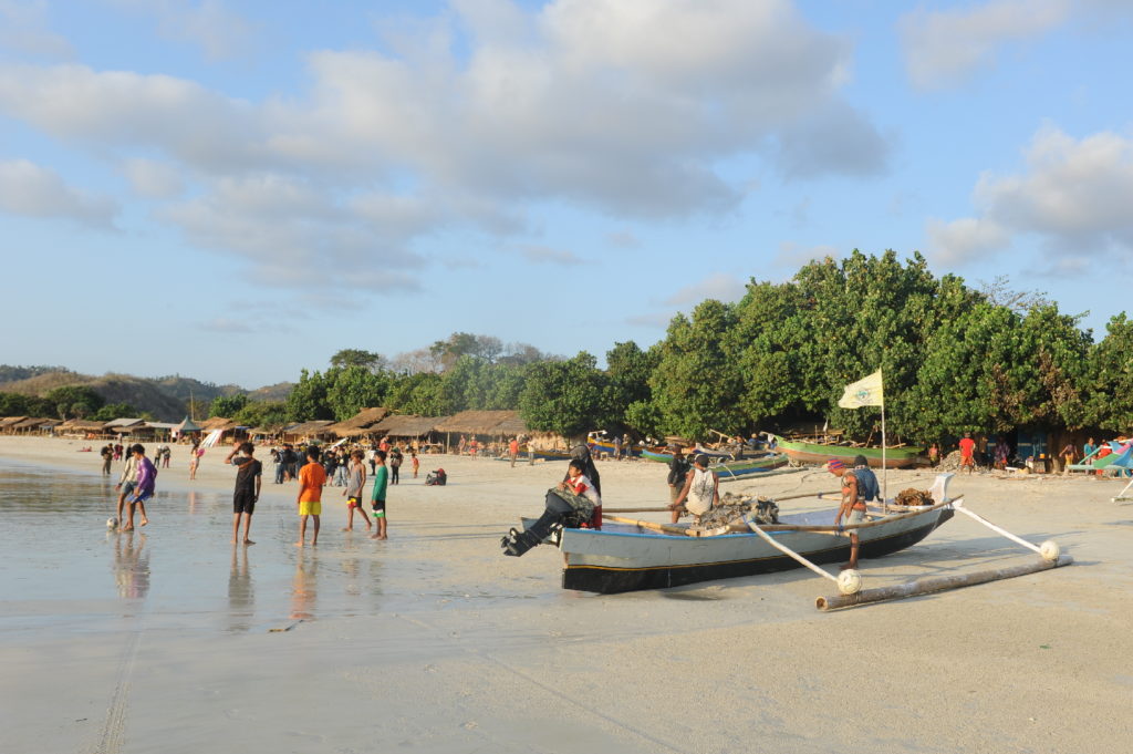 Selong Belanak, plage de rêve de Lombok, au coucher du soleil, pêcheurs s'apprêtant à partir