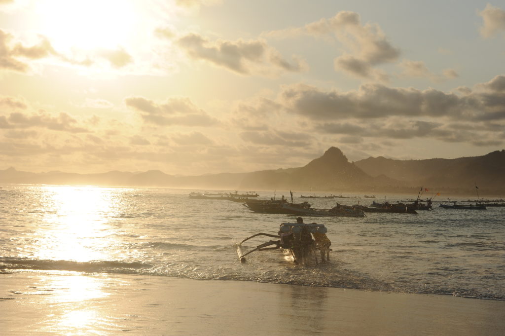 Selong Belanak, plage de rêve de Lombok, au coucher du soleil, pêcheurs partant au large