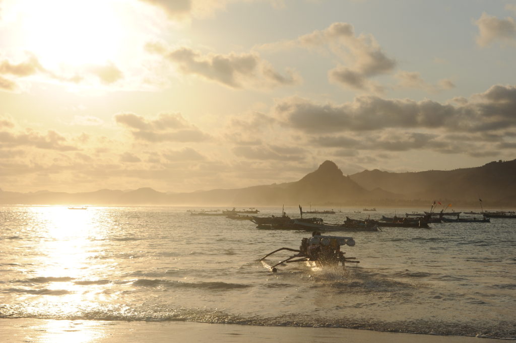 Selong Belanak, plage de rêve de Lombok, au coucher du soleil, pêcheurs partant au large