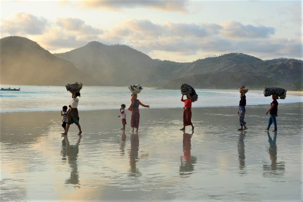 Selong Belanak, plage de rêve de Lombok, au coucher du soleil, femmes de pêcheurs défilant avec leurs paniers sur la tête