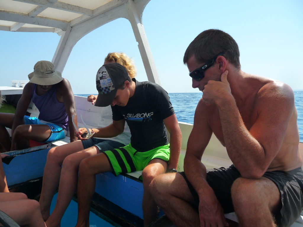 les hommes sur notre bateau à fond en verre pour aller faire du snorkeling au large des îles Gili
