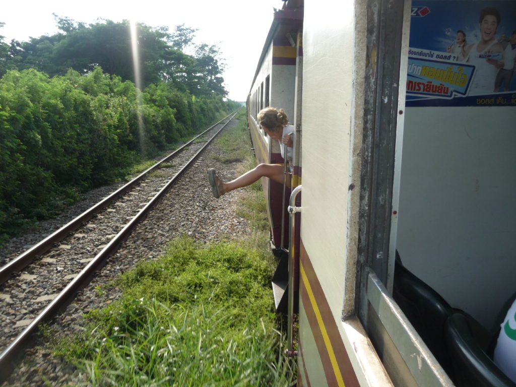 chatounette qui sort le corp par la fenêtre de notre train entre bangkok et kanchanaburi