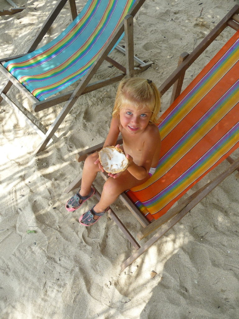 chatounette mange une noix de coco dans un transat sur "the best beach", la meilleure plage de koh lanta