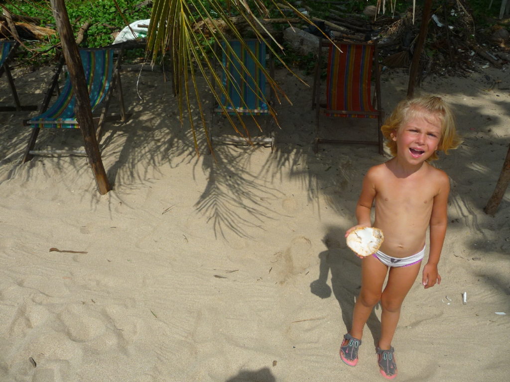 chatounette mange une noix de coco sur "the best beach", la meilleure plage de koh lanta