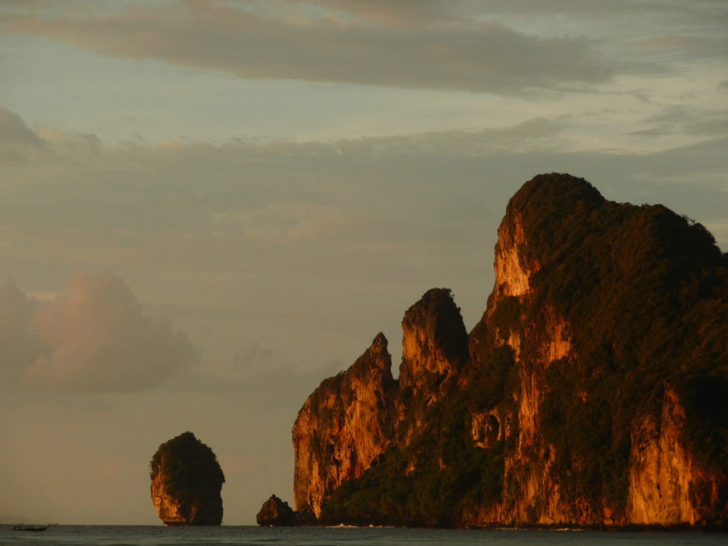 coucher de soleil depuis la plage de koh phi phi avec vue sur les parois karstiques