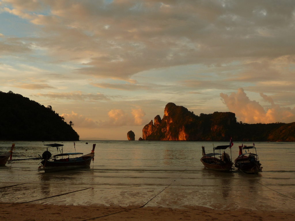 coucher de soleil sur la plage de koh phi phi avec les bateaux au premier plan