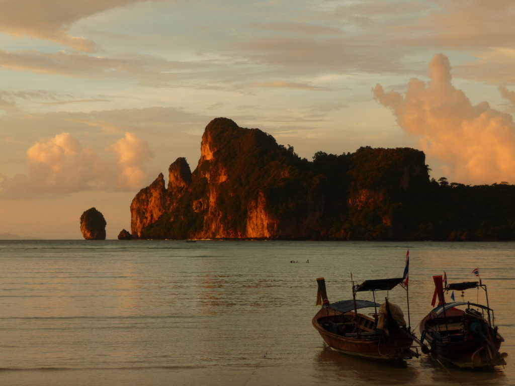 coucher de soleil sur la plage de koh phi phi avec les bateaux au premier plan