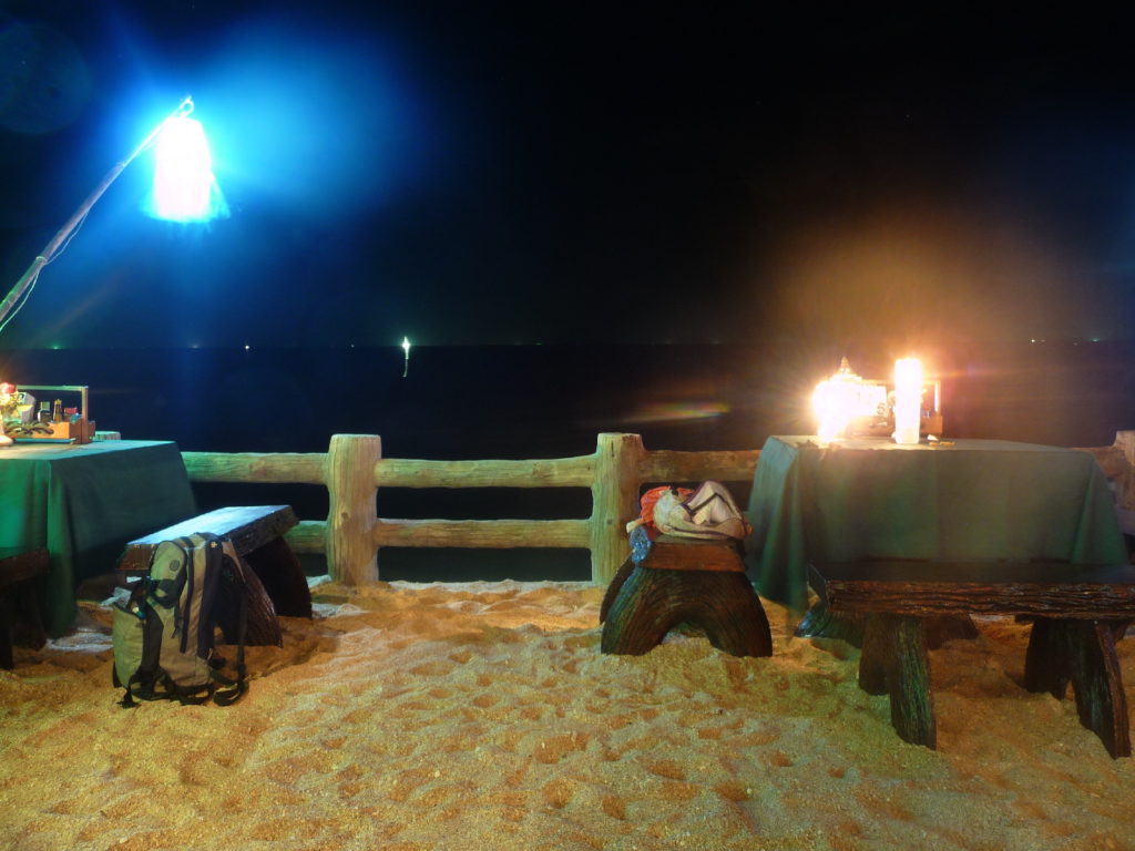 tables de notre restaurant entre la mer et la piscine la nuit à koh lanta
