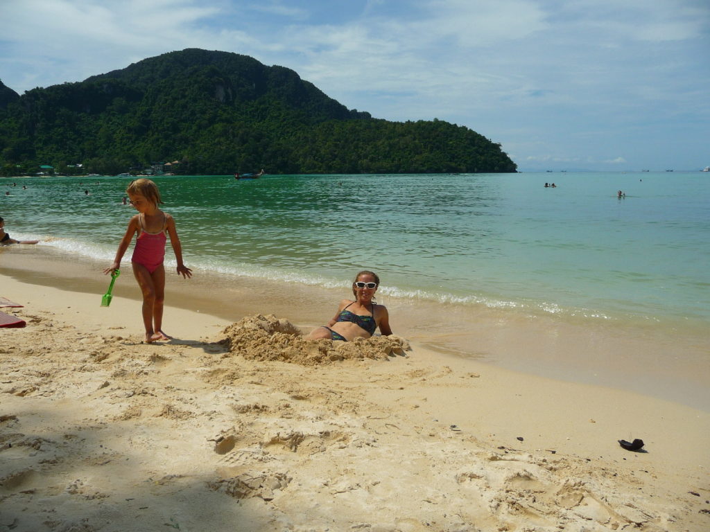 chatoune dans un trou dans le sable sur la plage de koh phi phi