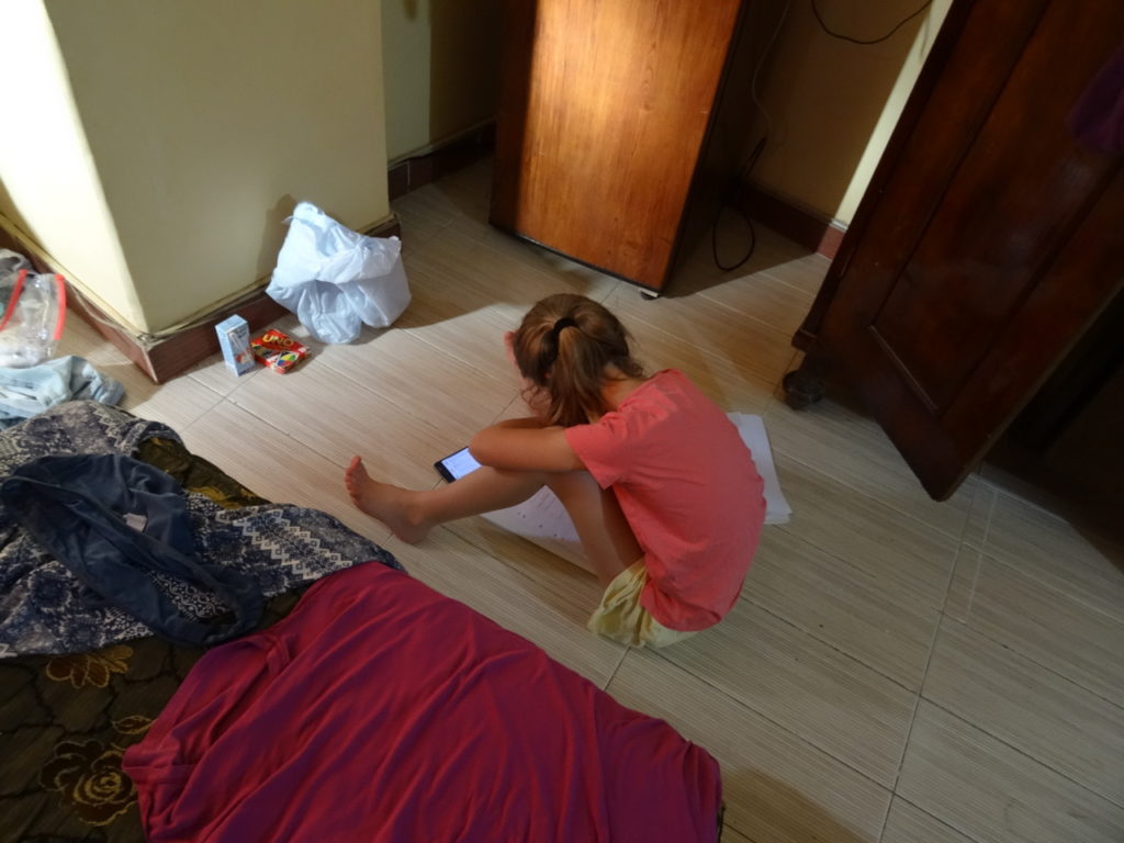 chatounette qui fait ses devoirs par terre dans la chambre d'hotel