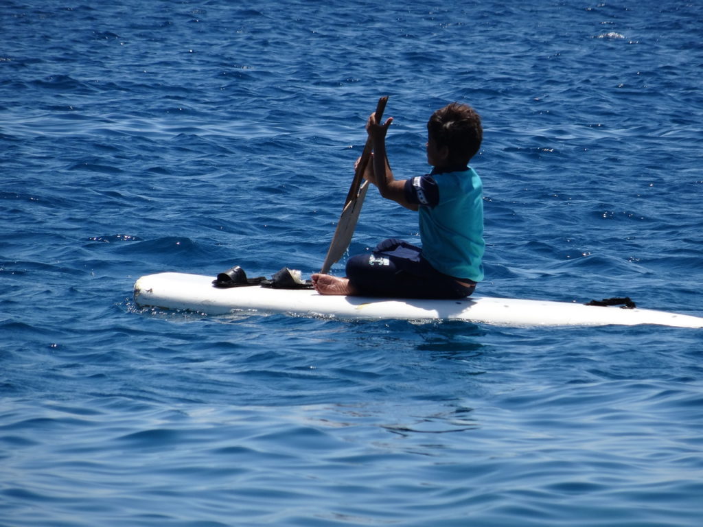 enfant qui rame sur une barque dans le port de pêche d'Hurghada
