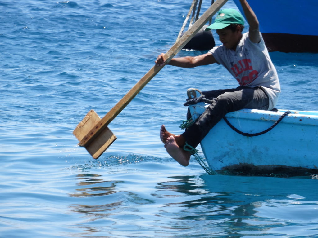 enfant qui rame sur une barque dans le port de pêche d'Hurghada