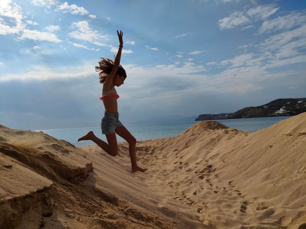 Chatounette saute dans les dunes de sable de la Plage de Milopotas, Ios, Cyclades