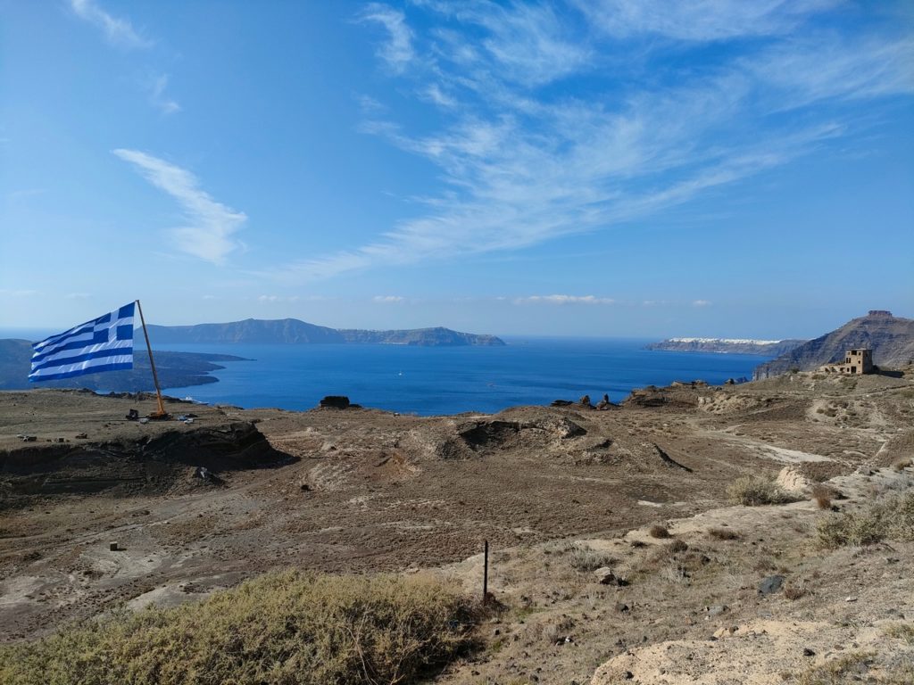 Tour de Santorin en voiture - drapeau géant de la grèce près de fira