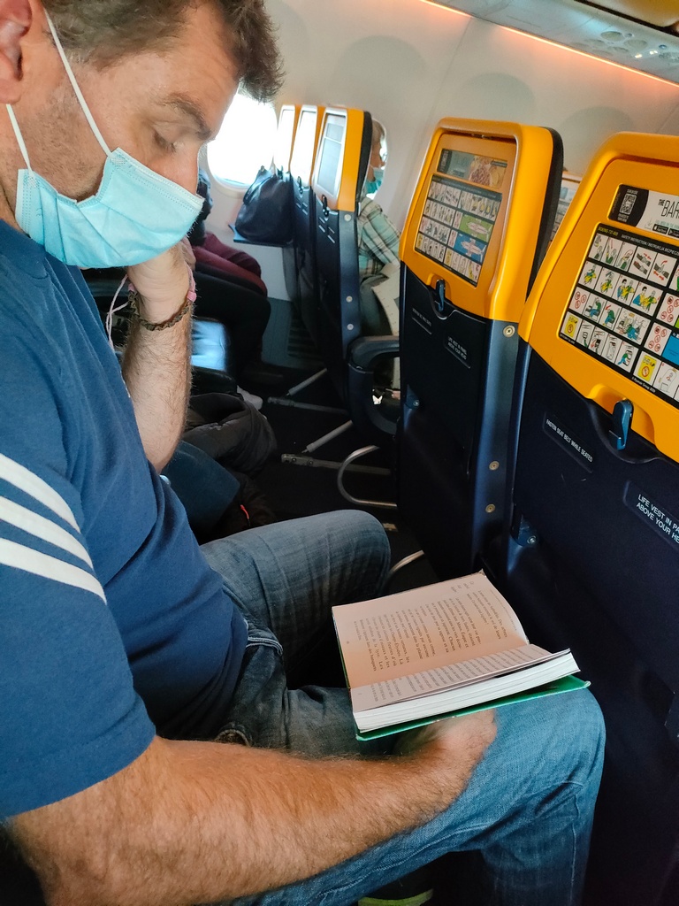 chaton en pleine lecture dans l'avion pour santorin