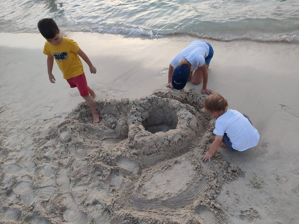 JBR Jubera Beach Residences plage de Dubaï au coucher du soleil, les enfants font un chateau de sable