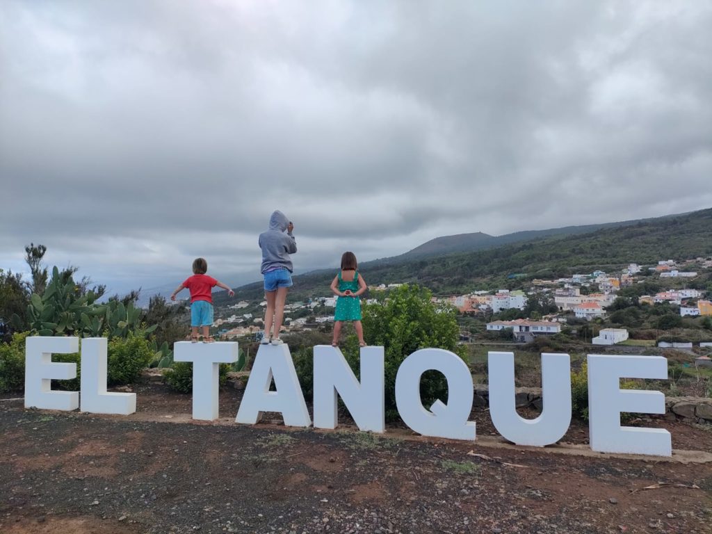 les enfants sont grimpés sur les lettres de El Tanque et contemplent le panorama sur la côte Nord de Ténérife